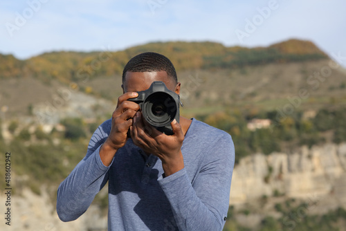 Man with black skin takes photos with dslr camera © PheelingsMedia