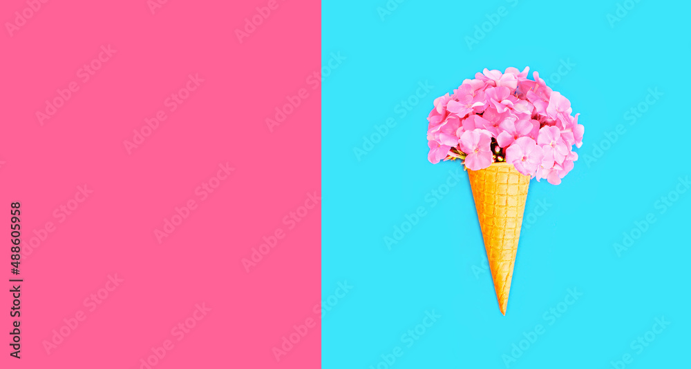 Cone ice cream with colorful flowers on blue background, blank copy space for advertising text Cone ice cream with colorful flowers on blue background, blank copy space for advertising text