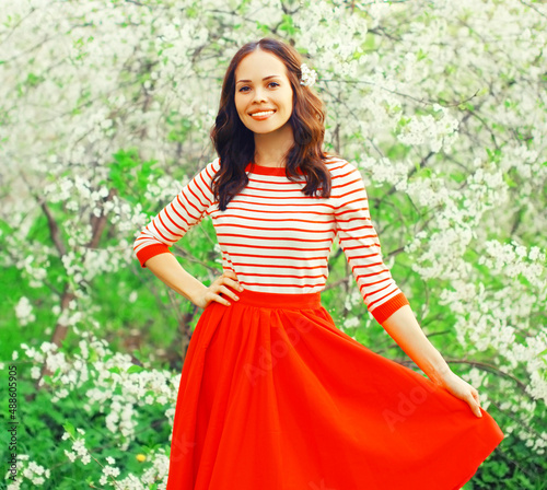 Portrait of beautiful lovely young woman in spring blooming garden on white flowers background