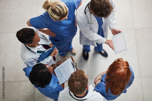 Monitoring the health of their patients. High angle shot of a group of medical practitioners working together in a hospital.