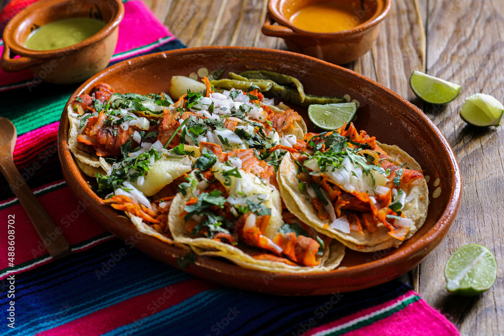 Mexican tacos al pastor accompanied by vegetables and sauces Mexican tacos al pastor accompanied by vegetables and sauces