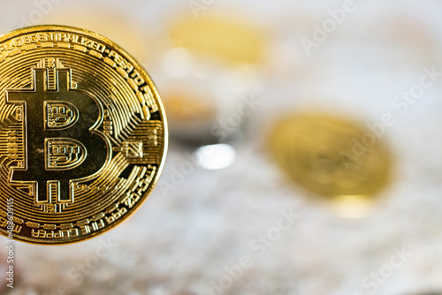 Close up one golden coin with the bitcoin symbol.