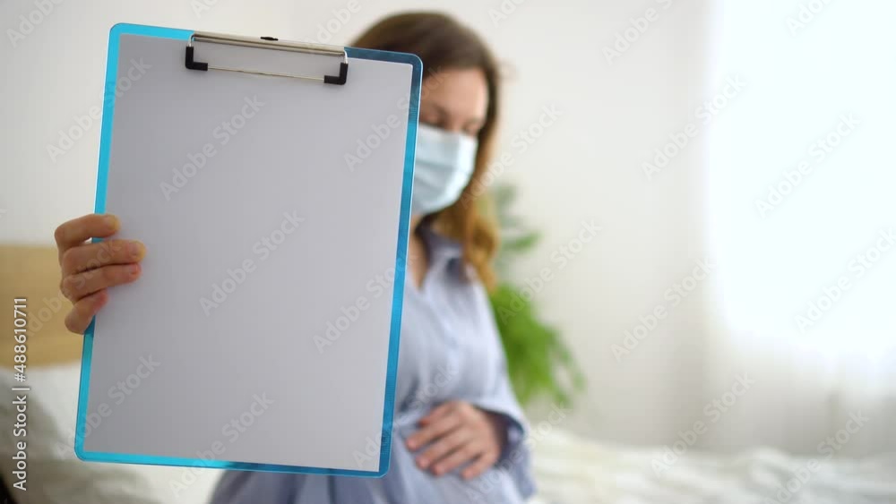 Pregnant woman hold blank white paper. Healthcare checkup during pregnancy. Medical card for pregnancy. Empty place for text. Clipboard with documents for signing Pregnant woman hold blank white paper. Healthcare checkup during pregnancy. Medical card for pregnancy. Empty place for text. Clipboard with documents for signing