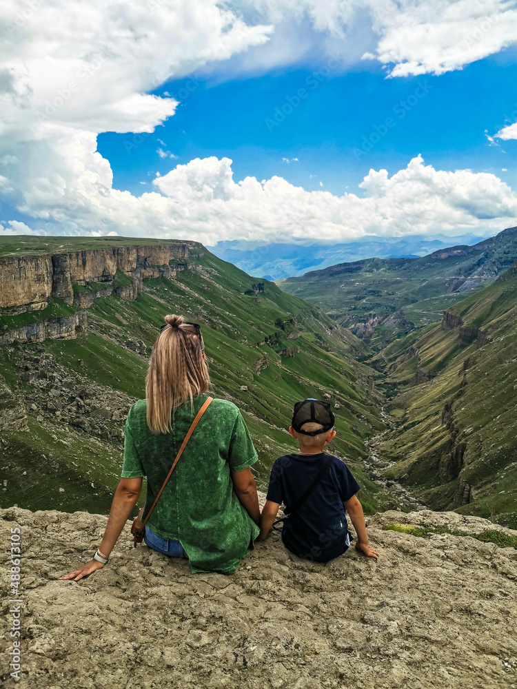 Naklejka premium A girl with a child on the background of the Khunzakh valley, Khunzakh waterfalls, Dagestan 2021
