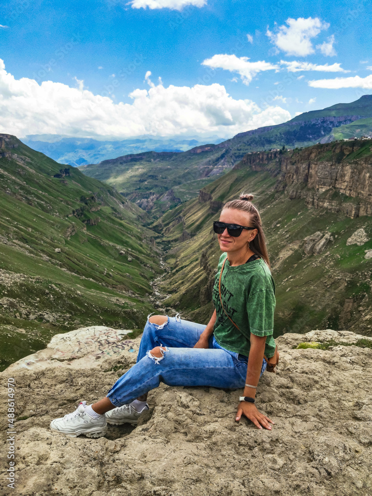 Naklejka premium A girl on the background of the Khunzakh valley, Khunzakh waterfalls, Dagestan 2021