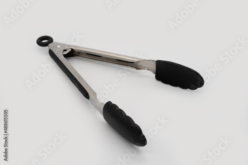 isolated stainless with rubber tongs utensil for cooking or preparing food on white background
