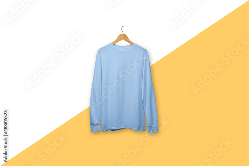 Blue long sleeve t-shirt on wooden hanger isolated on plain background