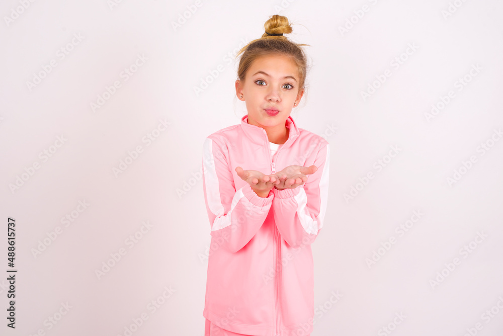 caucasian little kid girl with bun hairstyle wearing pink tracksuit ...