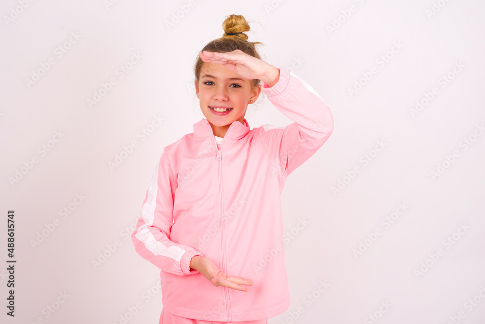 caucasian little kid girl with bun hairstyle wearing pink tracksuit ...