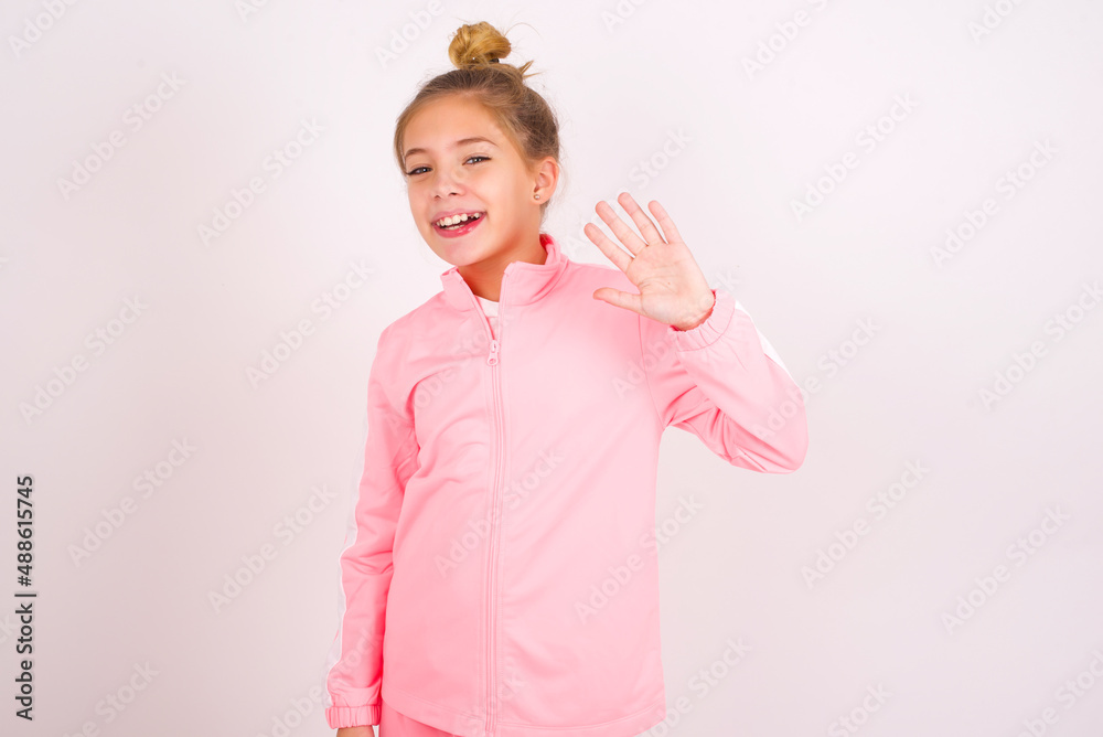 caucasian little kid girl with bun hairstyle wearing pink tracksuit ...