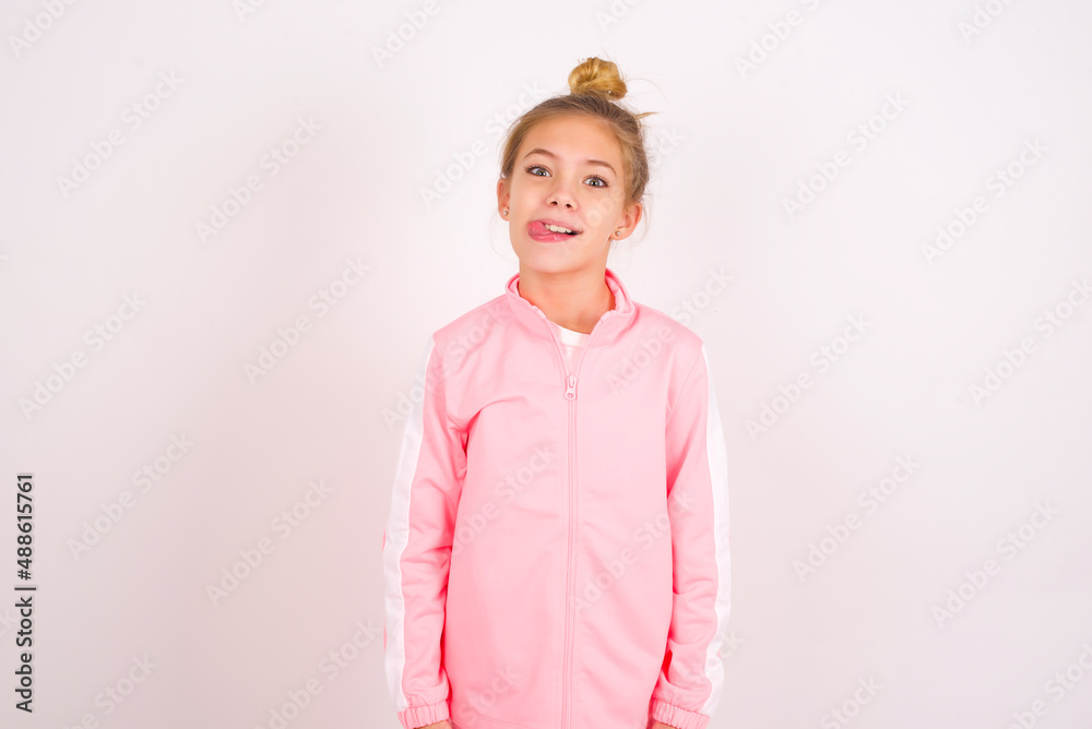 caucasian little kid girl with bun hairstyle wearing pink tracksuit ...