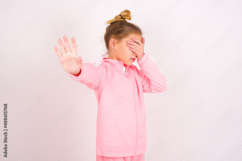 caucasian little kid girl with bun hairstyle wearing pink tracksuit ...