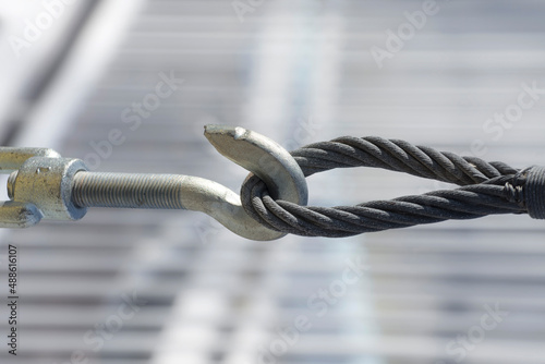 Steel turnbuckle and sling steel in construction site, close up. Fastening of cables with steel rod.