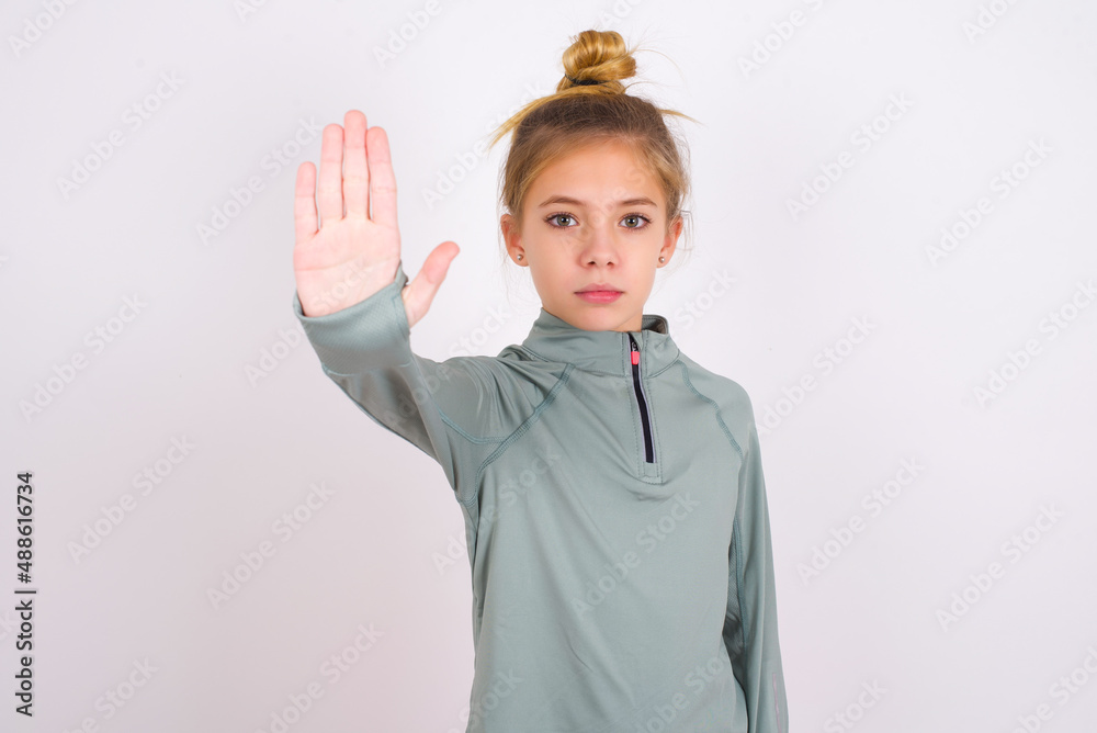 little caucasian kid girl with hair bun wearing technical shirt over ...