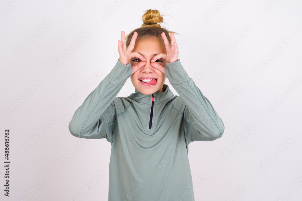 little caucasian kid girl with hair bun wearing technical shirt over ...