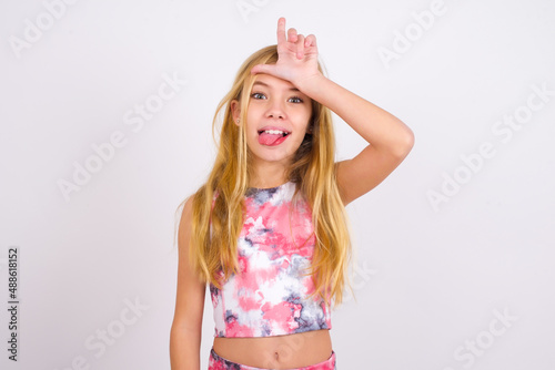 Konstfotografi little caucasian kid girl wearing sport clothing over white background gestures