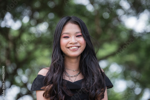 A young woman clearly showing her beautiful smile in front of the camera. Living in a happy life and prosperous experiences in her life.