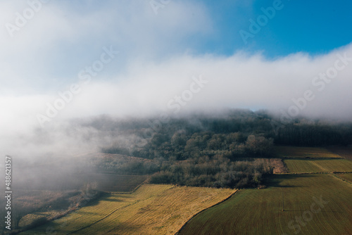 Un paysage de champs et un brouillard sur la montagne. La brume sur un paysage agricole. La campagne avec du brouillard sur des prés et une forêt.