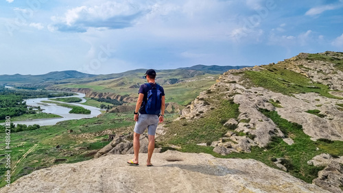 A male tourist enjyoing the view from the ancient cave city of Uplistsikhe overlooking the Mtkvari river in the Shida Kartli Region of Georgia,Caucasus,Eastern Europe. Exploration. Near Gori