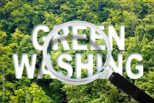 Fotografia Alert to Greenwashing - concept with text against a forest and trees and magnify