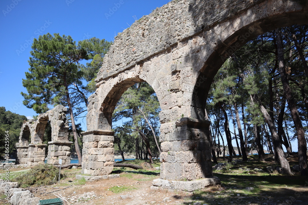 ruins of the ancient aqueduct in Phaselis, Turkey with the sea on the background
