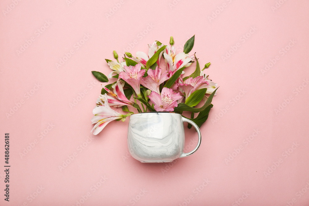 pink flowers in a cup on a pink background. top view 
