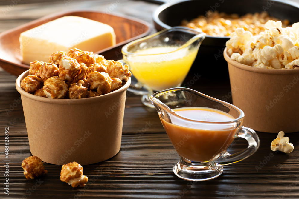 Paper buckets with butter and caramel popcorn on kitchen table
