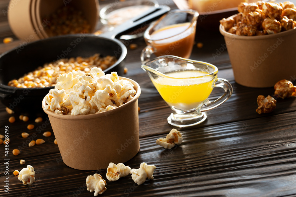 Paper buckets with butter and caramel popcorn on kitchen table