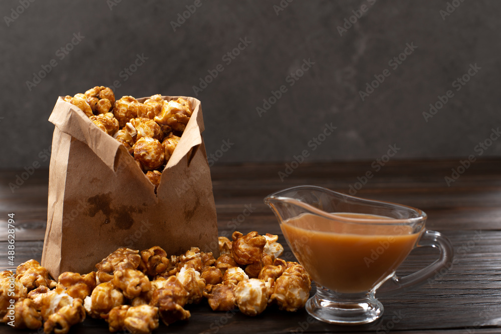 Caramelized popcorn in paper bag on wooden kitchen table