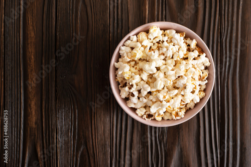 Obraz na płótnie Bowl with popcorn on dark wooden table with copy-space flat view w salonie