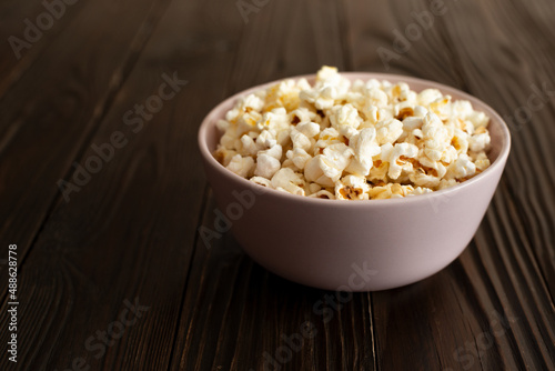 Obraz na płótnie Bowl with popcorn on dark wooden table with copy-space w salonie