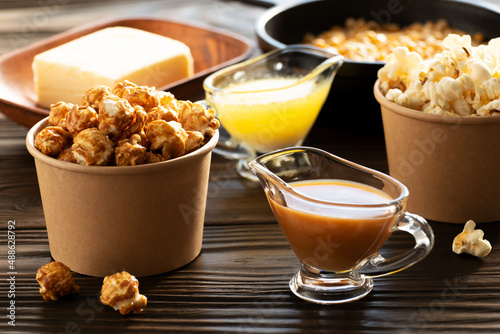 Obraz na płótnie Paper buckets with butter and caramel popcorn on kitchen table w salonie