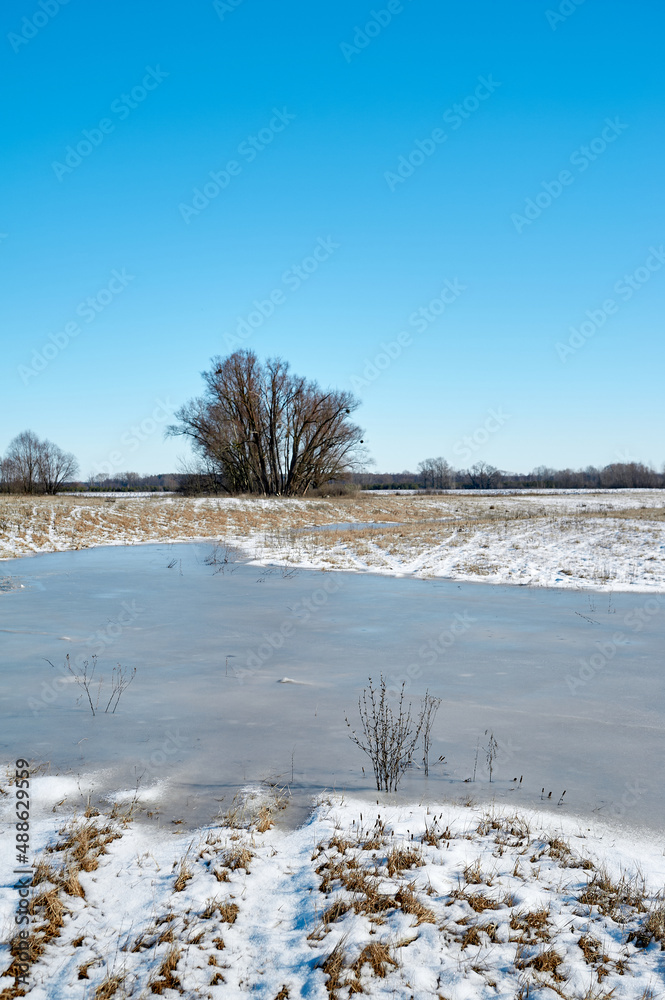 Frozen water, lake, in a field after winter Frozen water, lake, in a field after winter
