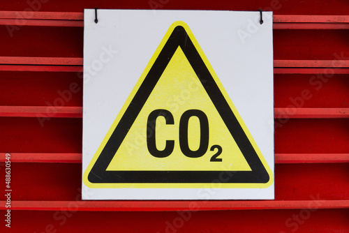 CO2 warning sign on a red background. Yellow triangle security labeled carbon dioxide.