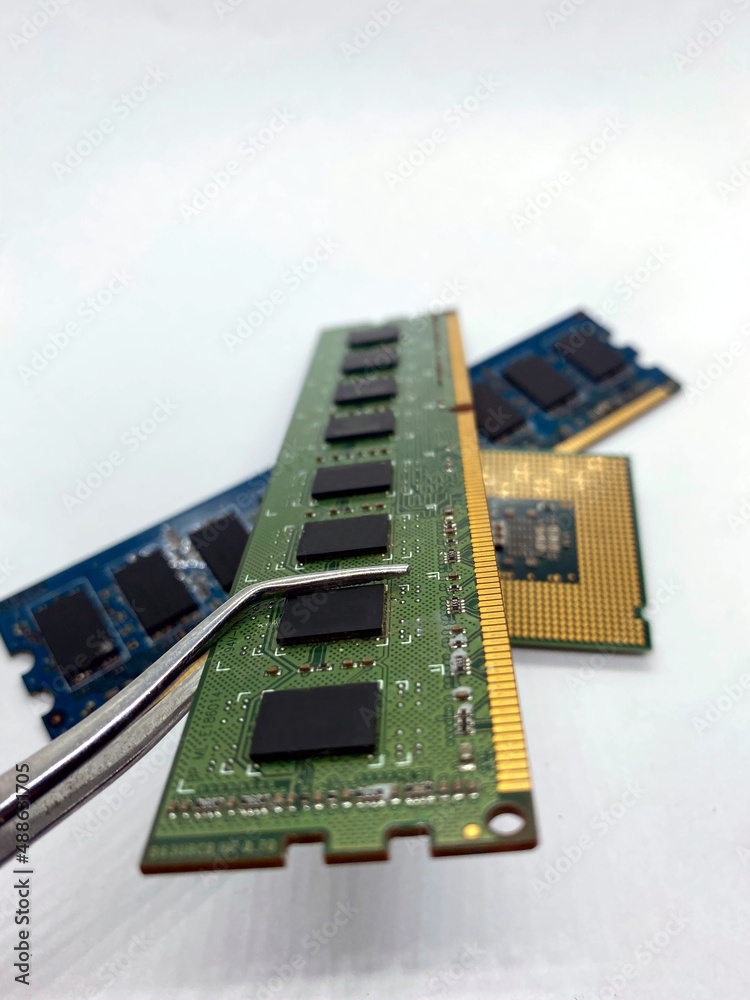RAM chip on pincer closeup with other chips on white background RAM chip on pincer closeup with other chips on white background