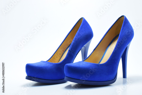 Zapatos azules de tacón alto para mujer. Calzado formal, para fiesta o trabajo sobre un fondo blanco. Espacio para texto al lado izquierdo.
