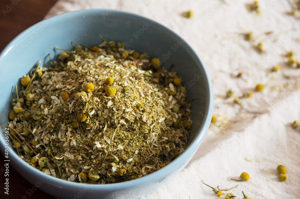 Dried chamomile inside blue bowl top view Dried chamomile inside blue bowl top view