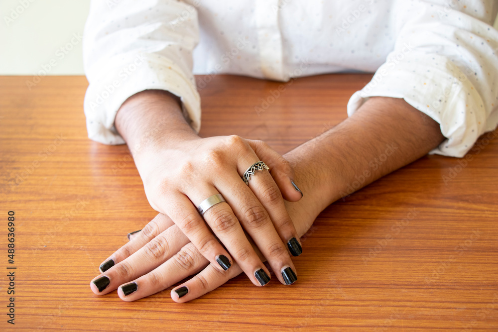 Beautiful woman's hand crossed on top of table