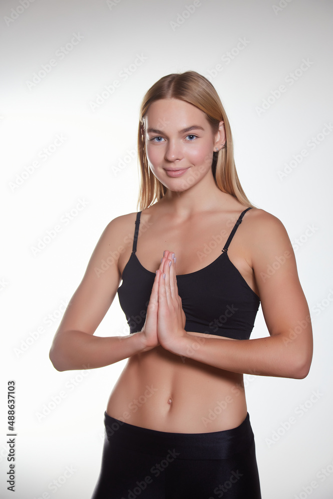 Smiling yoga instructor showing namaste gesture, workout in gym, meditating in sportsbra and leggings Smiling yoga instructor showing namaste gesture, workout in gym, meditating in sportsbra and leggings