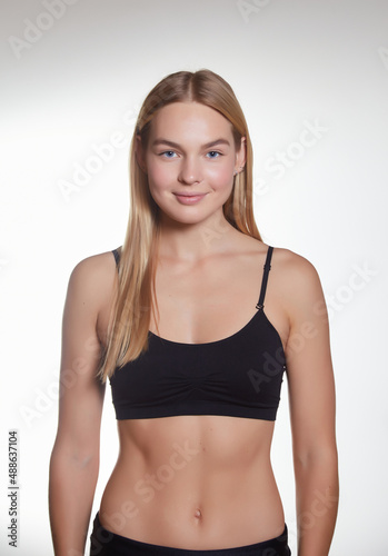 Studio portrait of a young pretty girl with a sporty physique on a studio background.