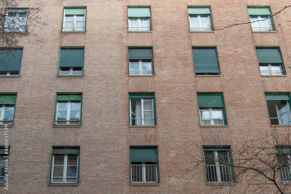 brick facade with rectangular windows of a building from the 30s in Madrid. Spain