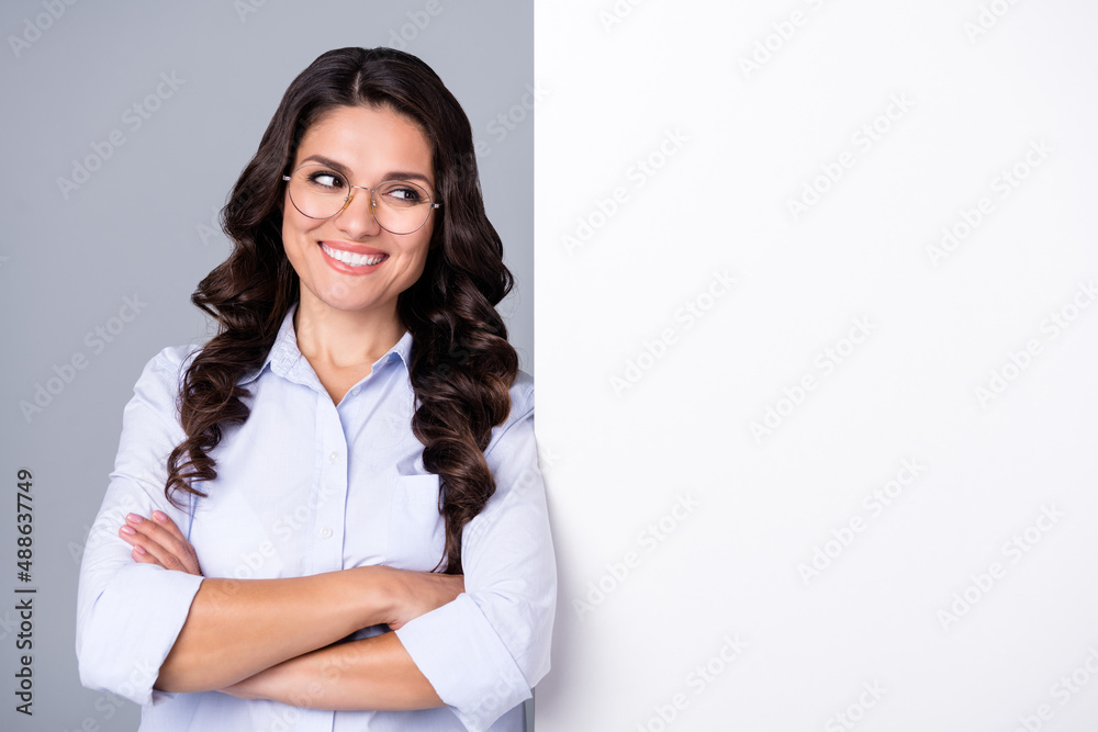 Photo of successful dreamy lady crossed hands look empty space wear glasses blue shirt isolated grey color background Photo of successful dreamy lady crossed hands look empty space wear glasses blue shirt isolated grey color background
