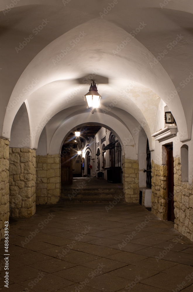 Old historic corridor at night. Arched vault. Stone walls