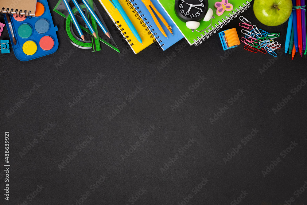 Obraz premium Black chalkboard school background with school supplies and stationery items, empty copy space for text