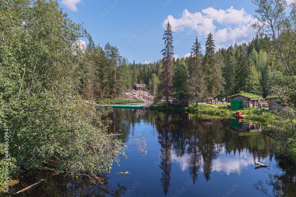 blue forest lake with small wooden houses for tourists on the shore. Karelia. Russia