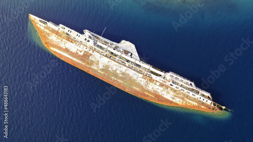 Obraz na plátně Aerial drone photo of rusty Mediterranean sky passenger ship sunk near shore o