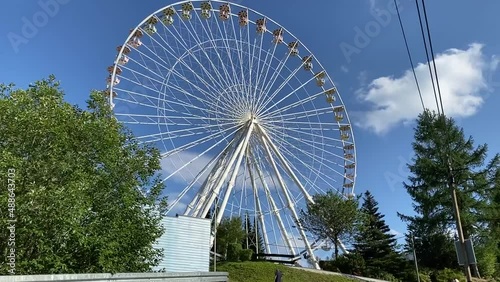Ferris wheel in an amusement park, good weather, blue sky
