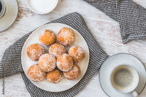 Fototapeta Naklejka Na Ścianę i Meble -  Fried curd balls with sugar on white wooden background, top view. Concept of coffee break. Copy space.
