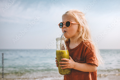 Fotomurale Kid girl drinking smoothie on beach healthy eating lifestyle vegan food breakfas