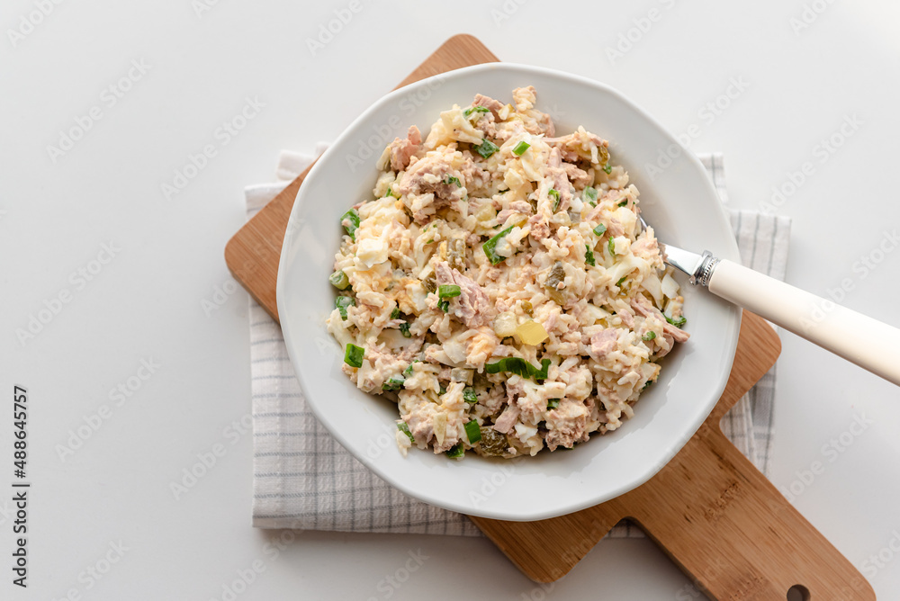 Salad with rice, tuna, egg, pickled cucumber, and chives.